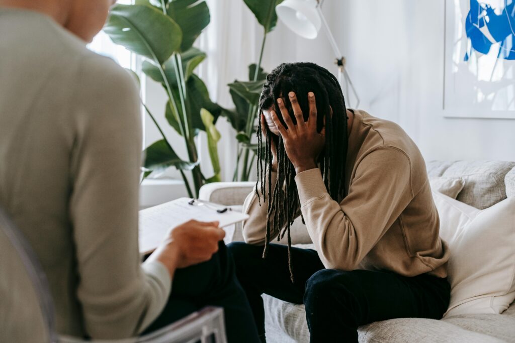 Man in therapy with his hands covering his head.
