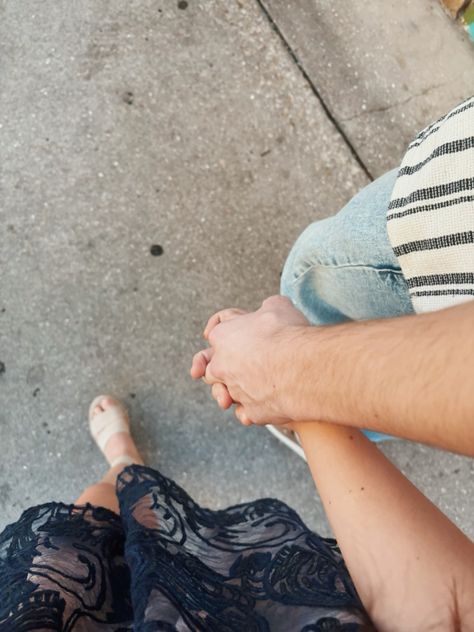 Couple holding hands walking.