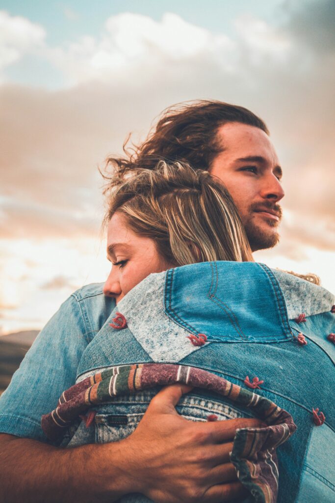 Couple hugging each other outside.
