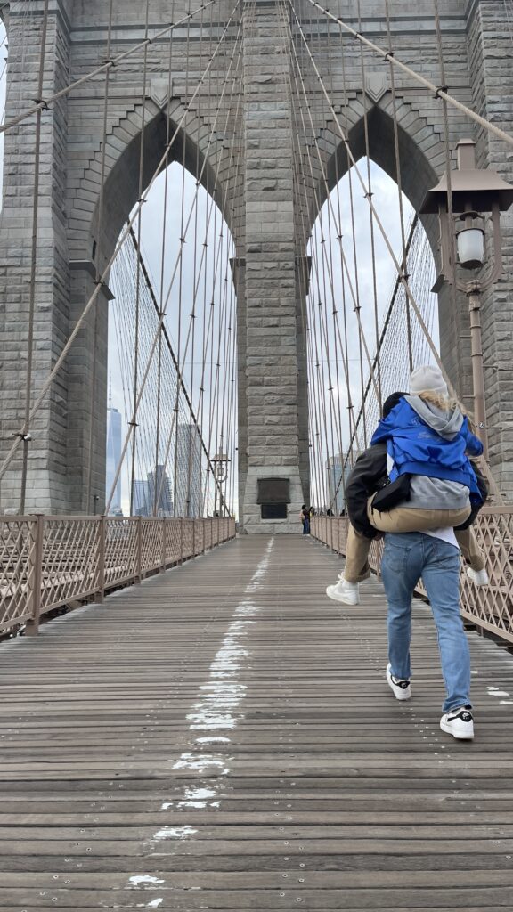 Couple piggy back walking on bridge.