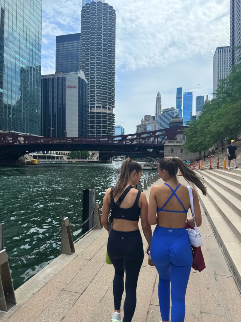Friends walking in city along water together.