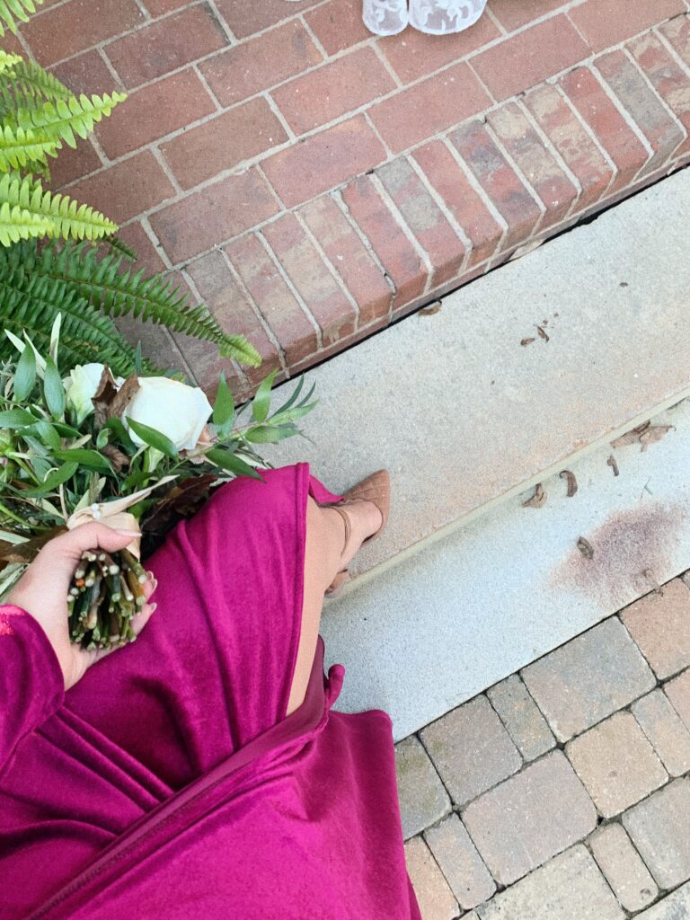 Sorority girl walking in heels holding flowers.