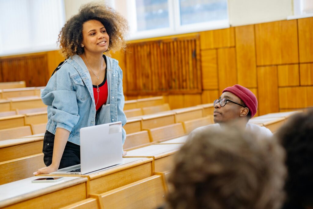 Student talking with other students in a classroom.