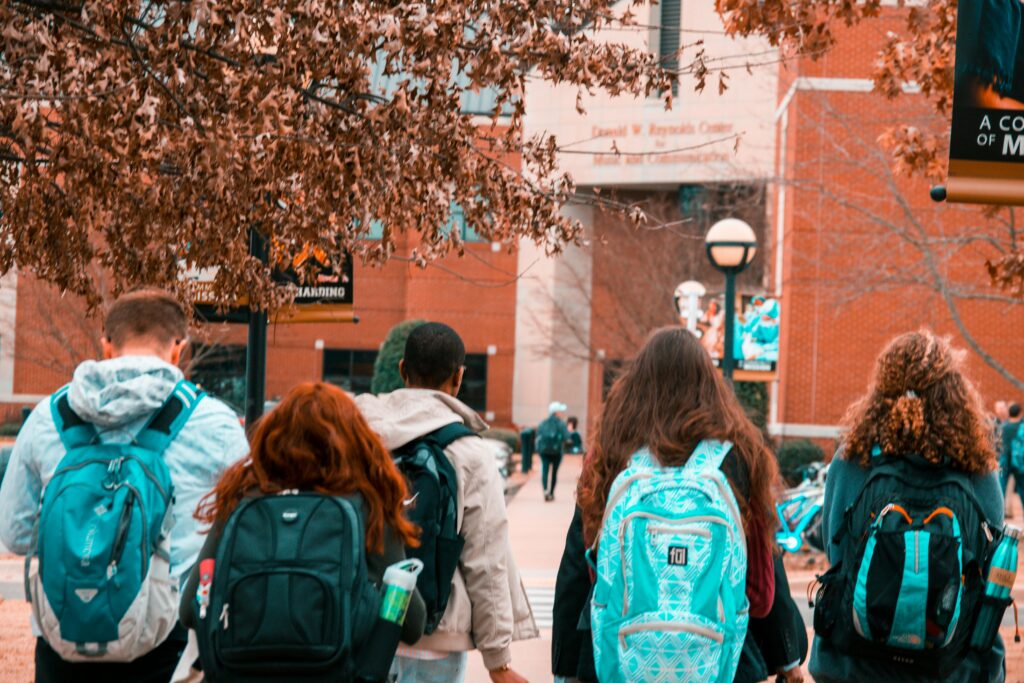 Group of students walking into school with backpacks on.
