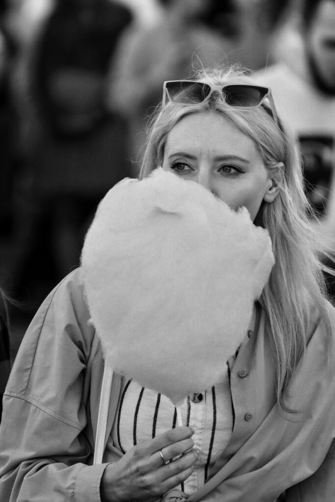 Black and white photo of woman eating cotton candy.