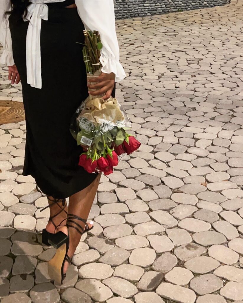 Girl walking and holding roses.