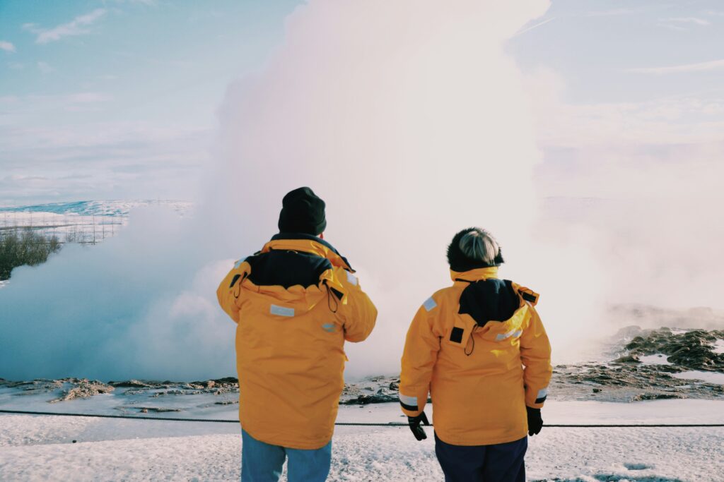 Two people looking out at the snow together on a trip.