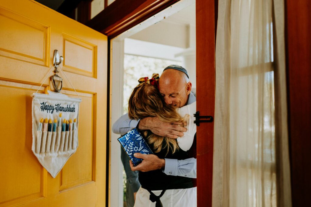 Dad and daughter hugging by the front door during Hannukah.