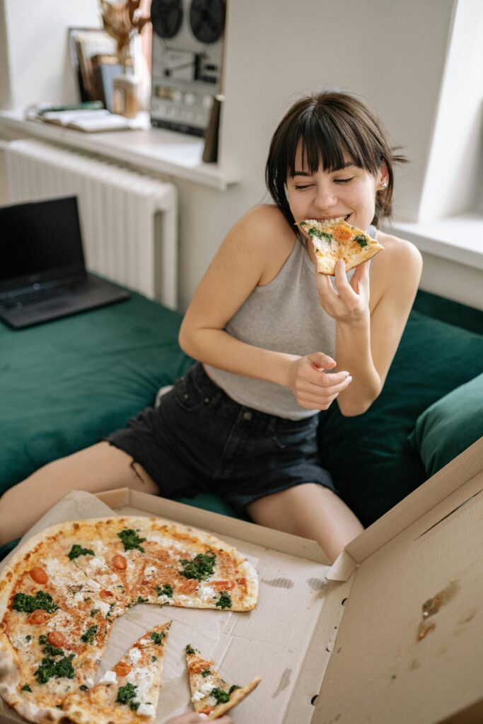 Woman happily eating pizza. 