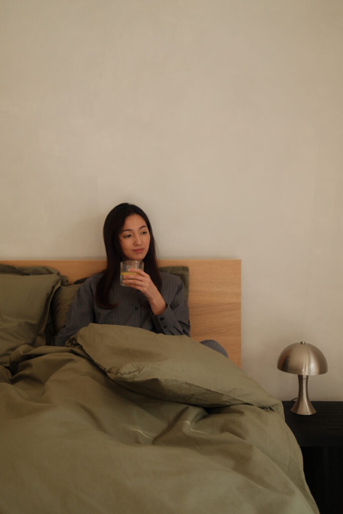 Calm woman relaxing in her bed drinking tea.