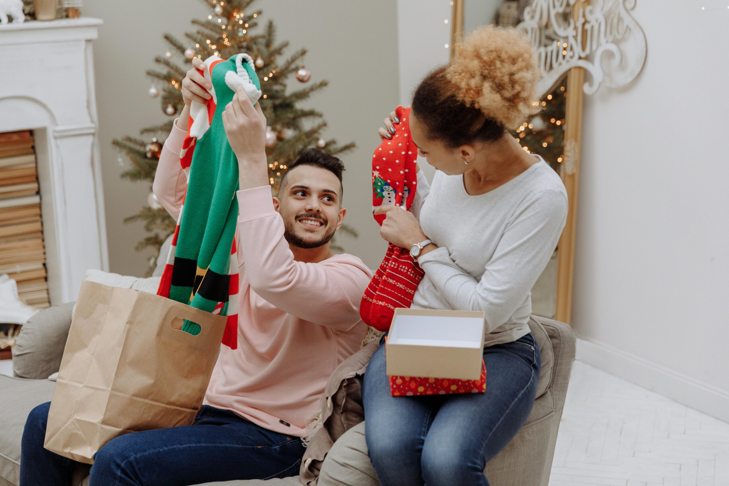 Couple opening Christmas presents together.