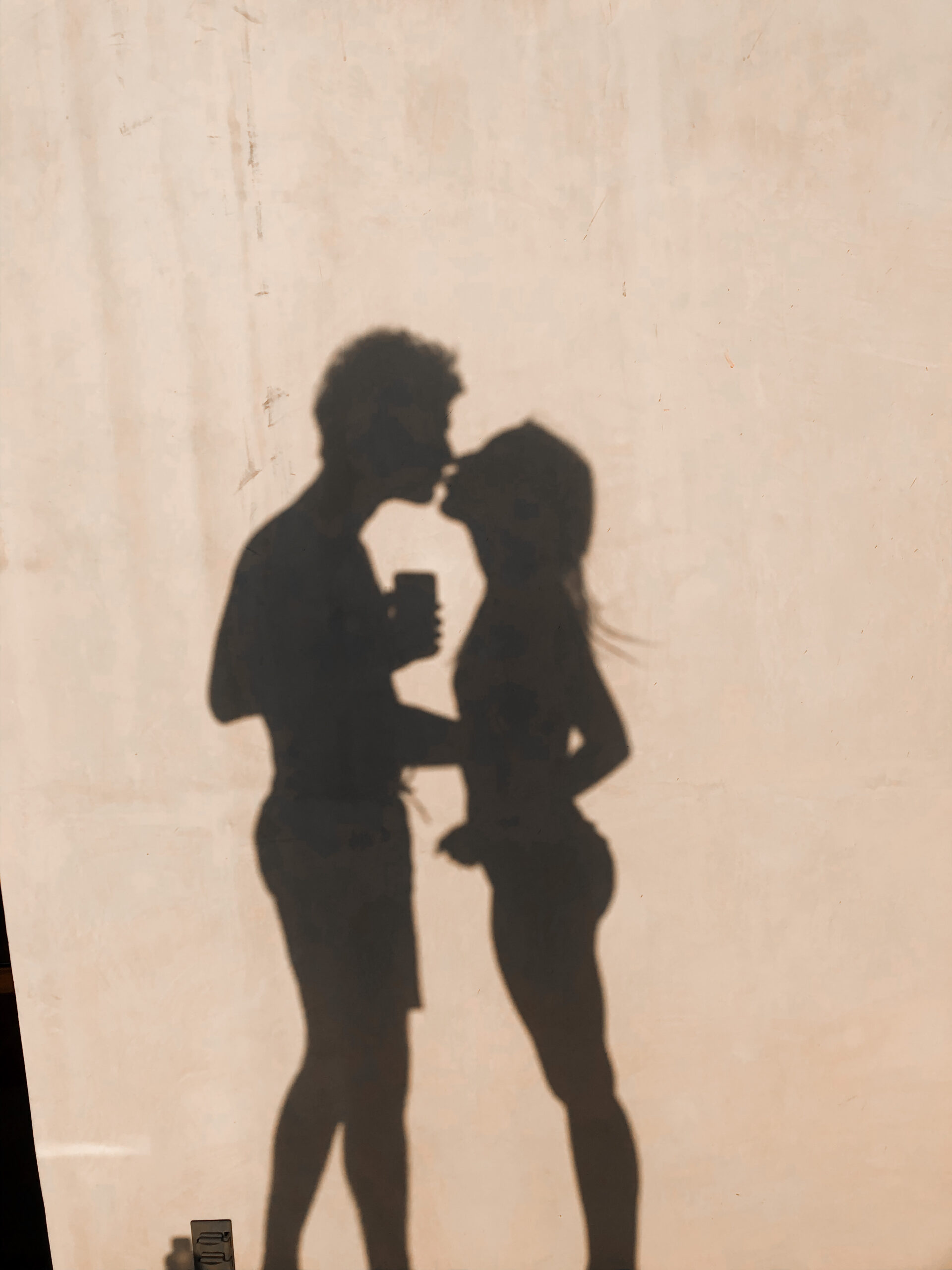 Shadow of couple kissing.