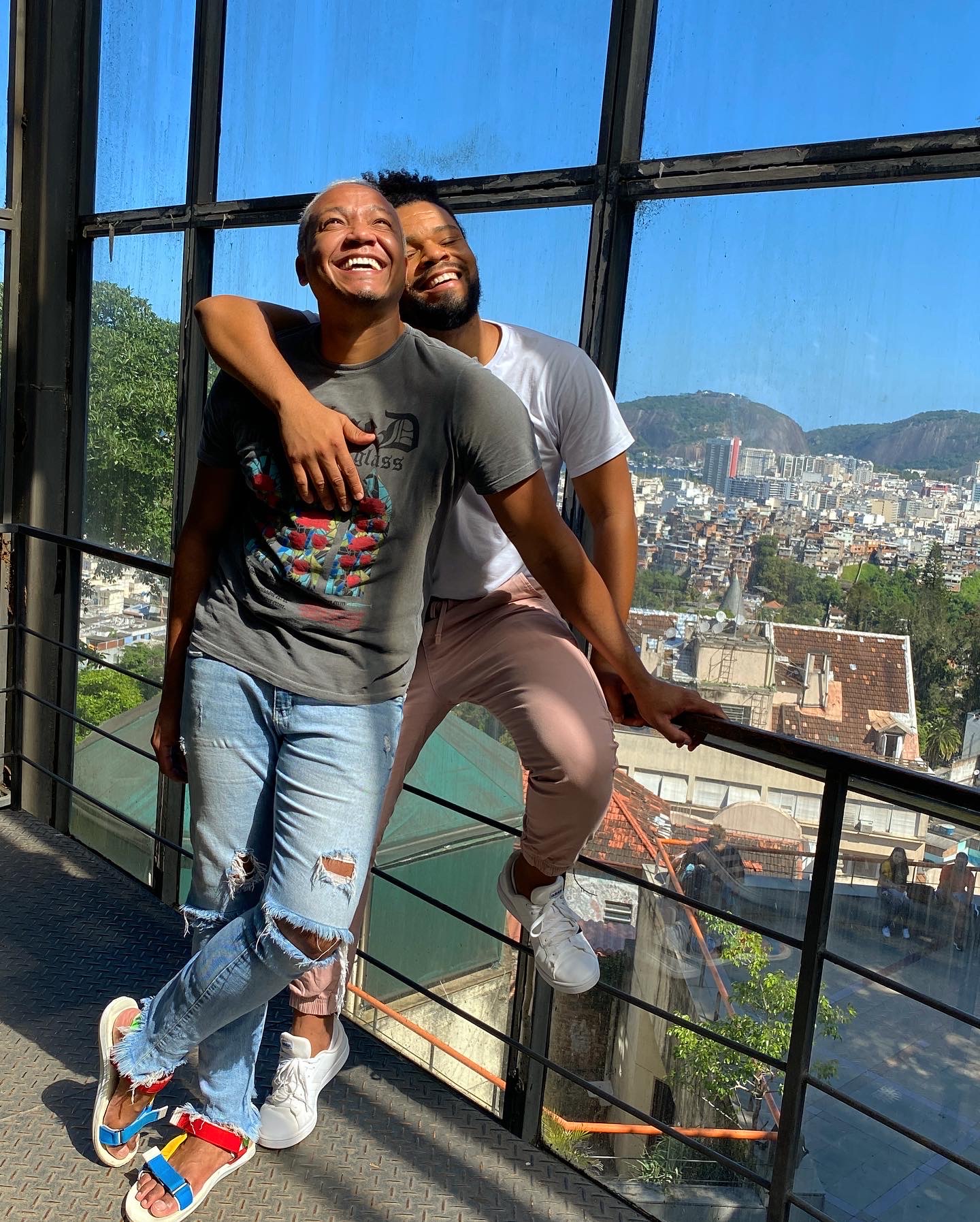 Couple laughing together sitting on ledge.