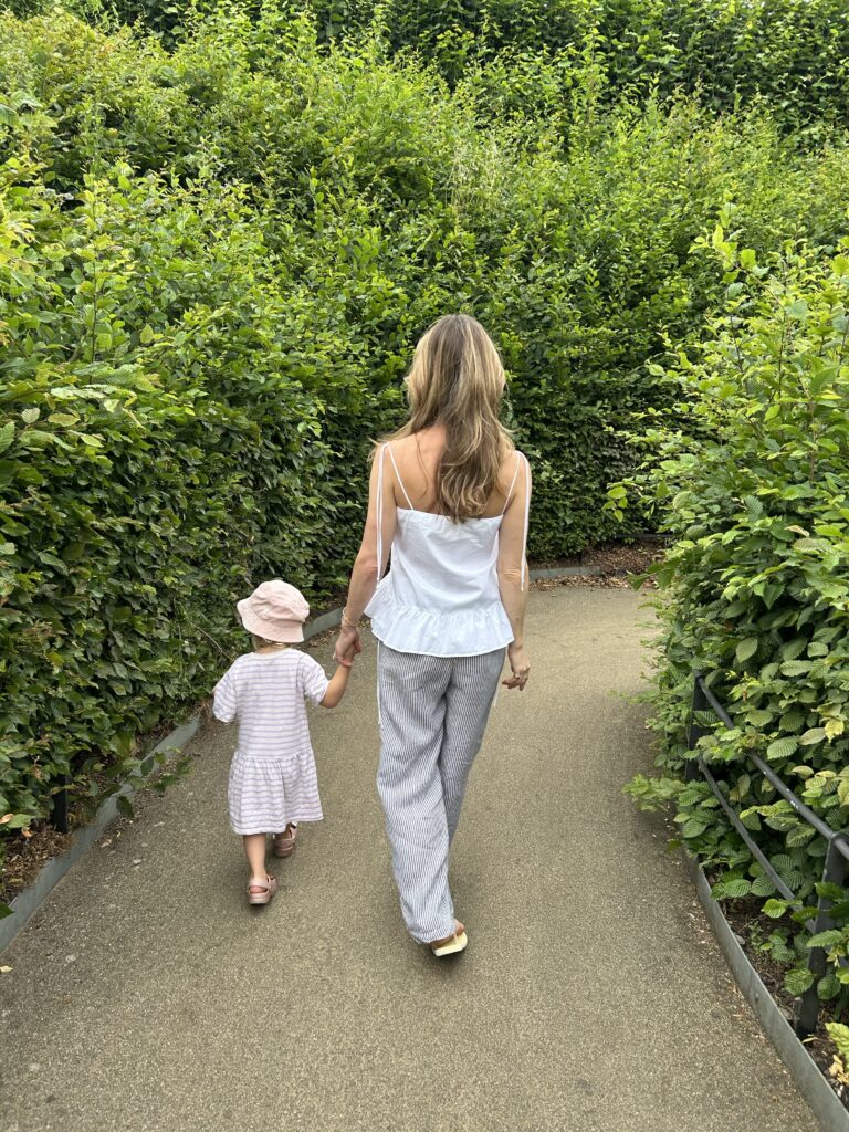 mom and child walking in between trees