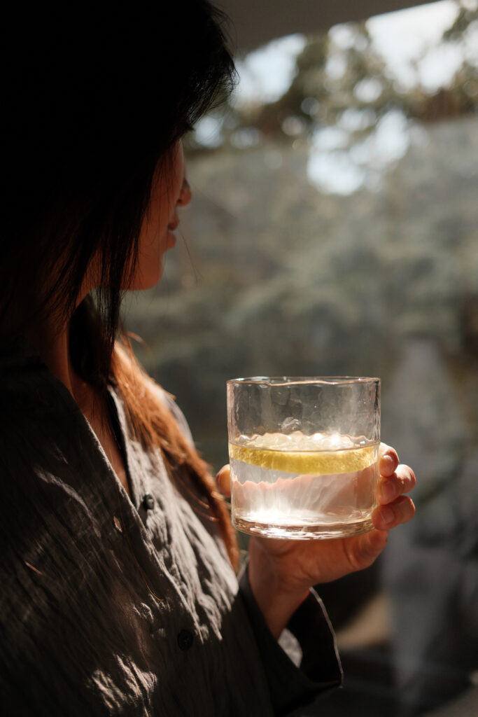 woman drinking lemon water and relaxing _ Manhattan _ stress _ college life _ 10014 _ 10013 _ 10011 Woman drinking lemon water looking out the window.