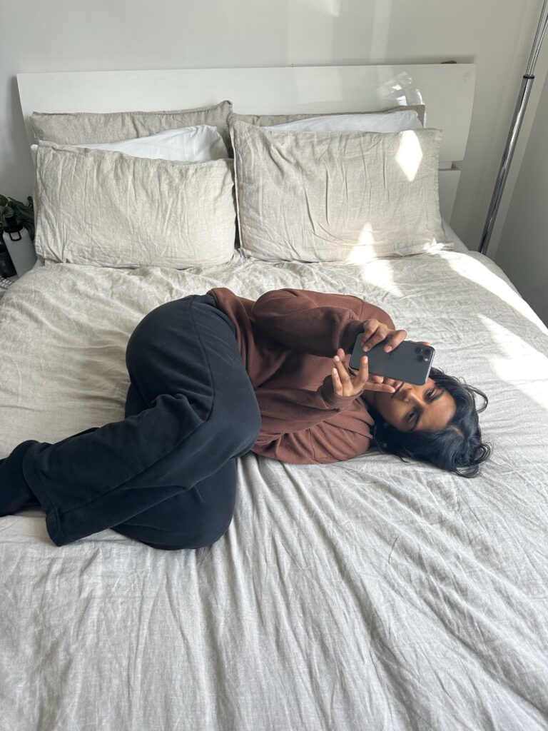 Single girl scrolling through dating apps in bed at New York City 