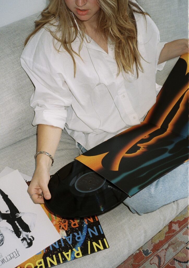 A girl opening up her new vinyl to listen to music taking care of her mental health in Manhattan