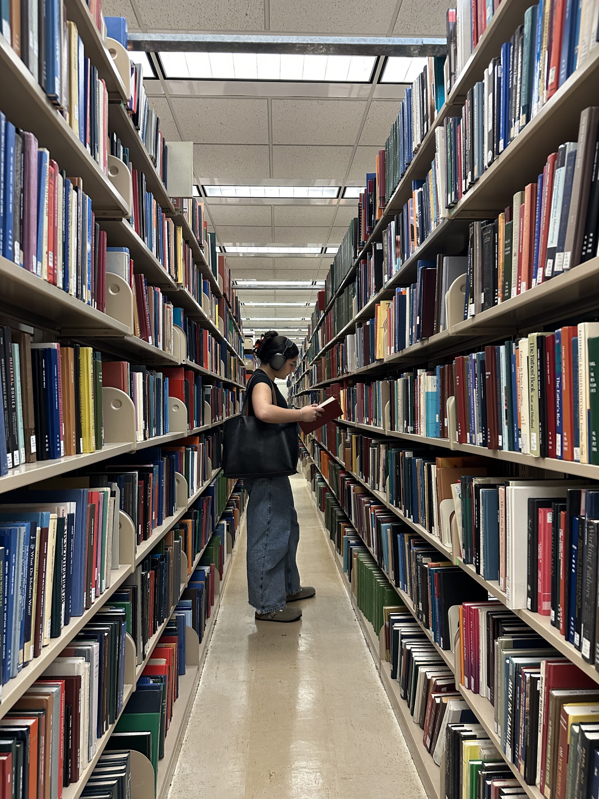 College girl in the library in Brooklyn looking for a book to study