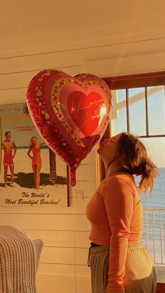 Woman kissing a heart-shaped balloon loving herself in New York