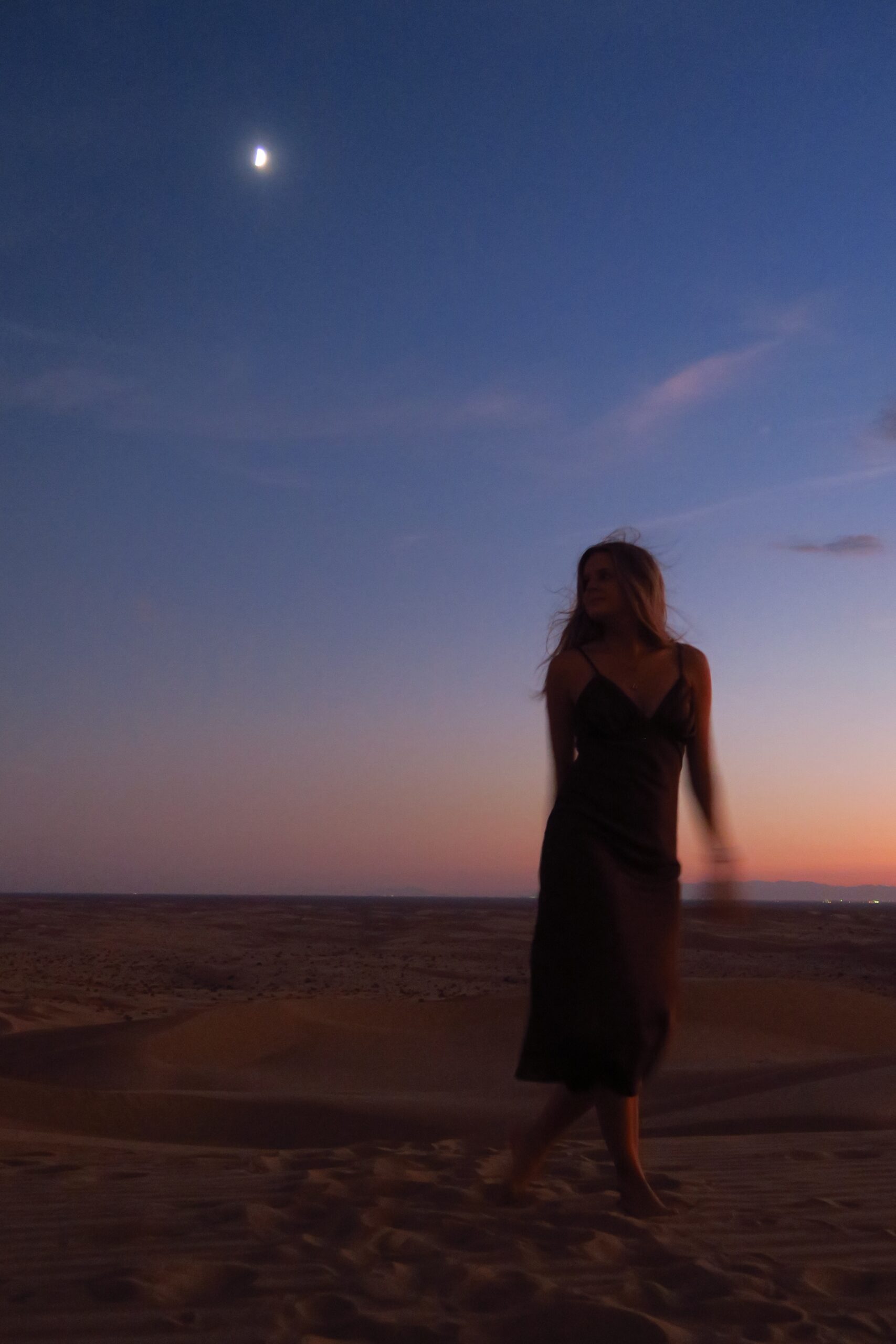 Woman standing on the beach at sunset loving herself in Manhattan