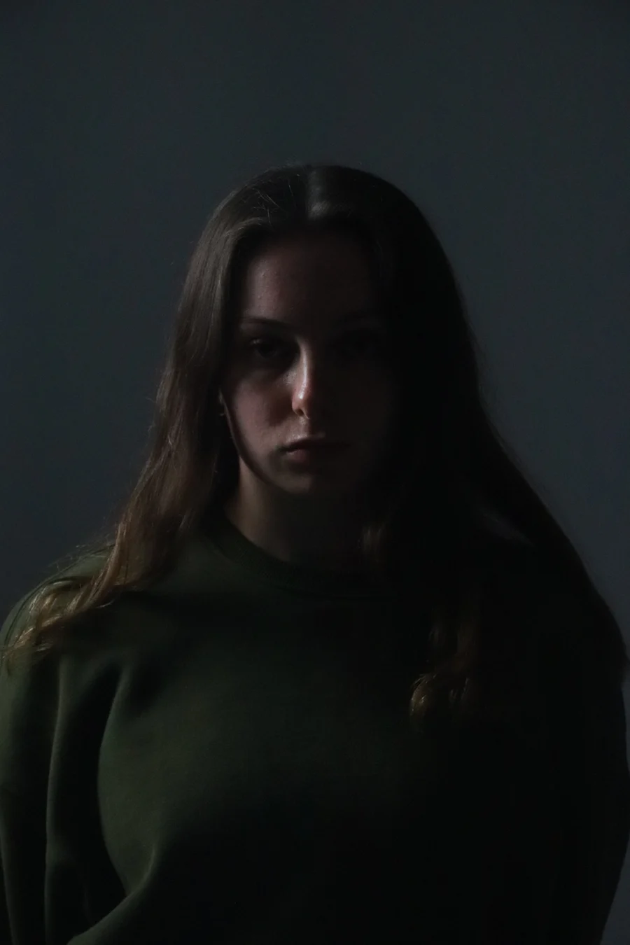 Girl stressed and spacing out in a dark room in Manhattan