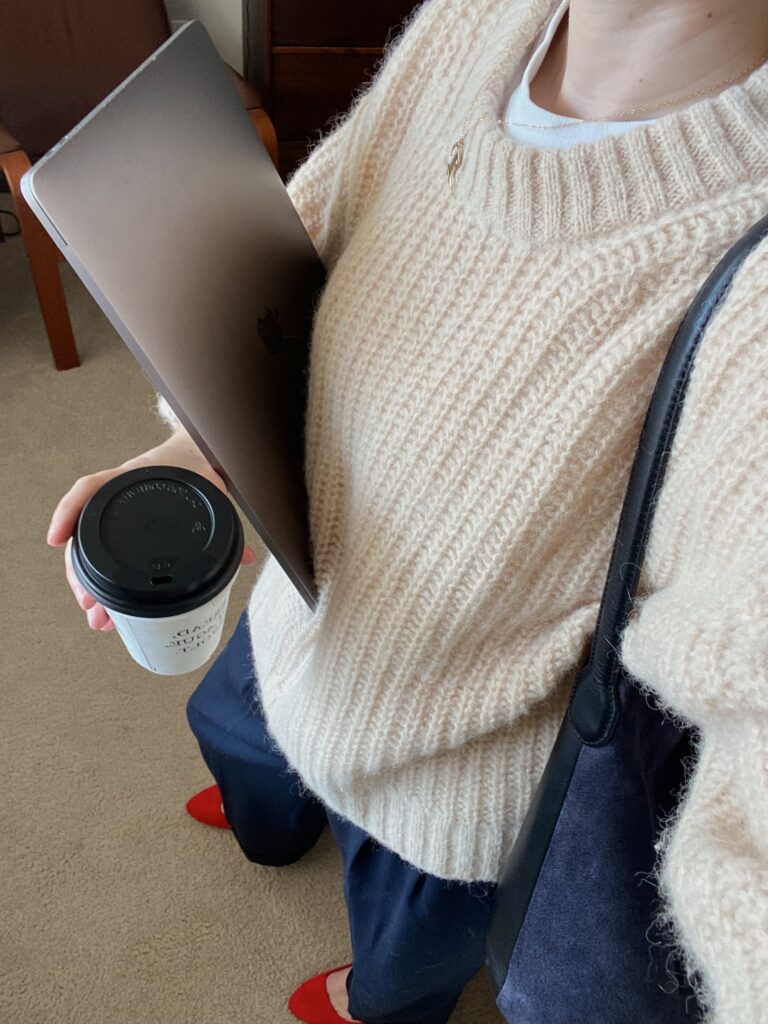 Girl holding a coffee and her laptop rushing to work at Brooklyn