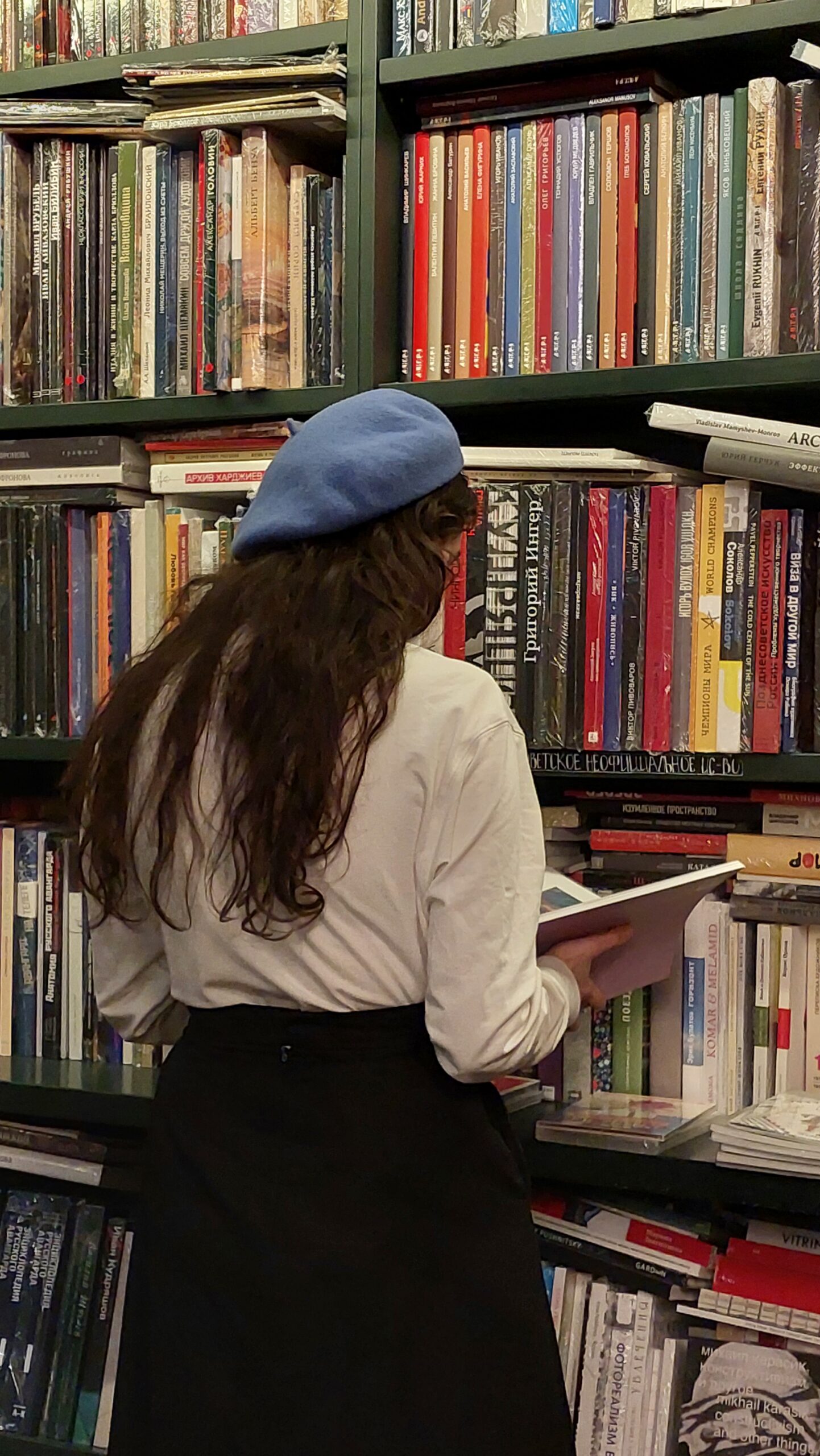 Girl student reading books for upcoming exams in the library at Manhattan