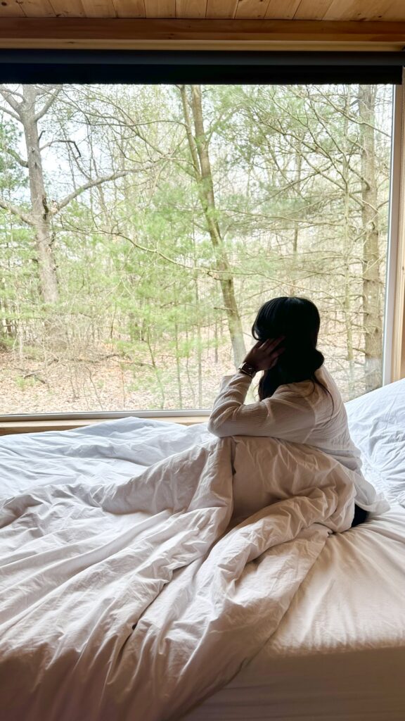 Woman sitting on her bed and doesn't have the energy to do anything at New York