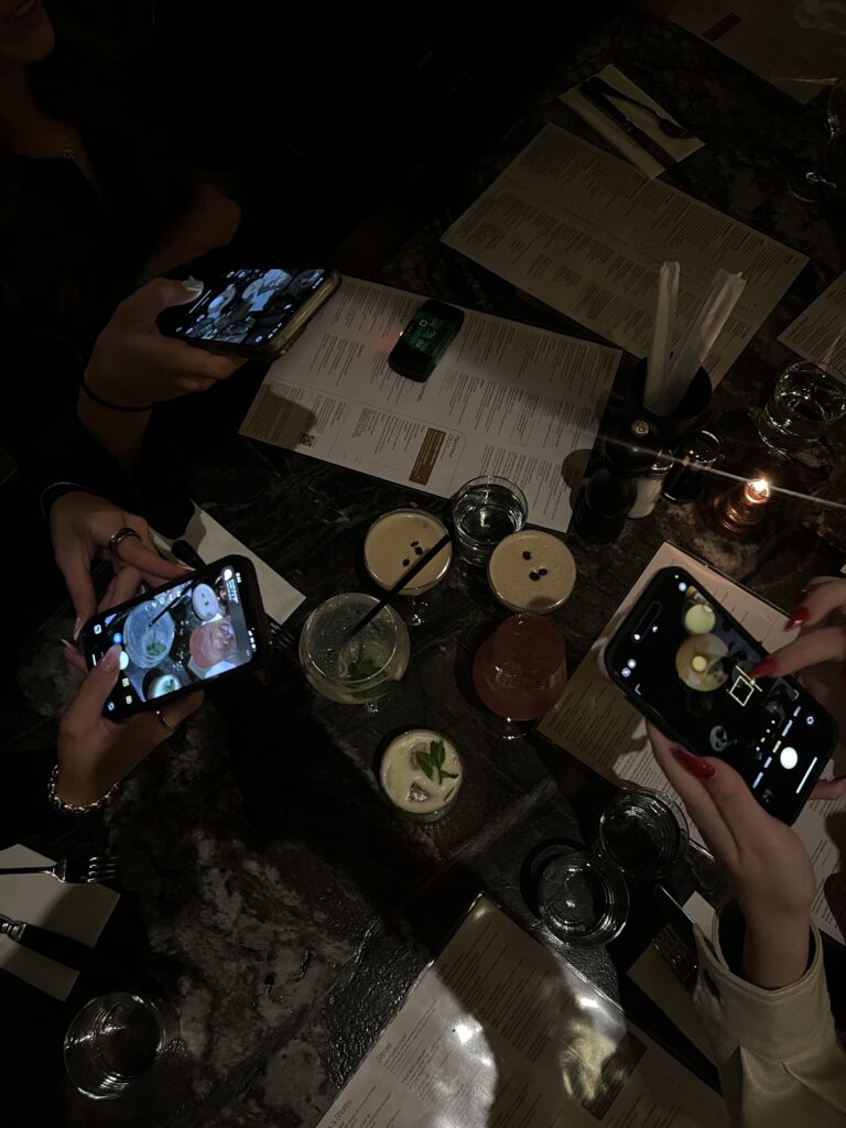 Friends taking pictures instead of talking to each other and enjoying the night at Manhattan
