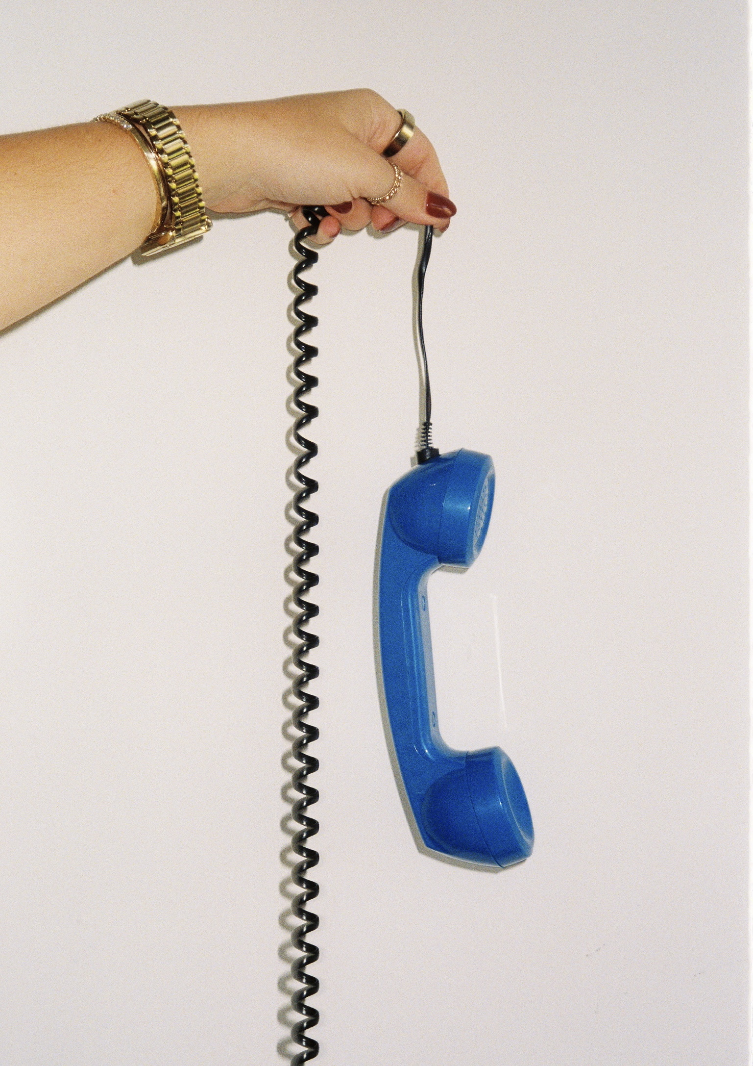 A woman holding to the wire of the vintage telephone barely listening to the voicemail at Manhattan