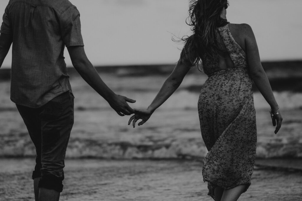A picture perfect of a couple walking by the beach without obvious conflict at Manhattan