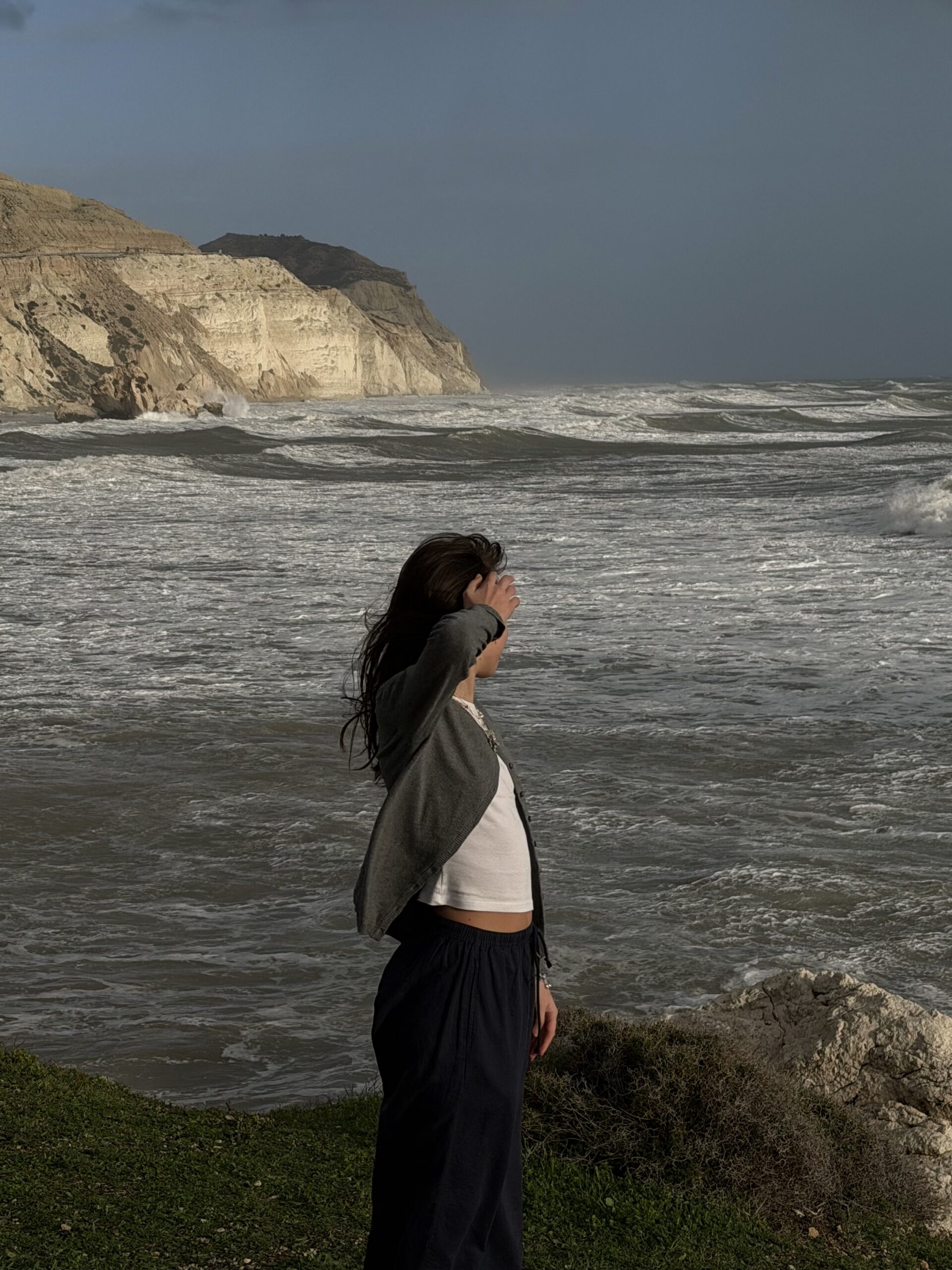 Woman feeling the breeze and getting a breath of fresh air at the beach in Manhattan
