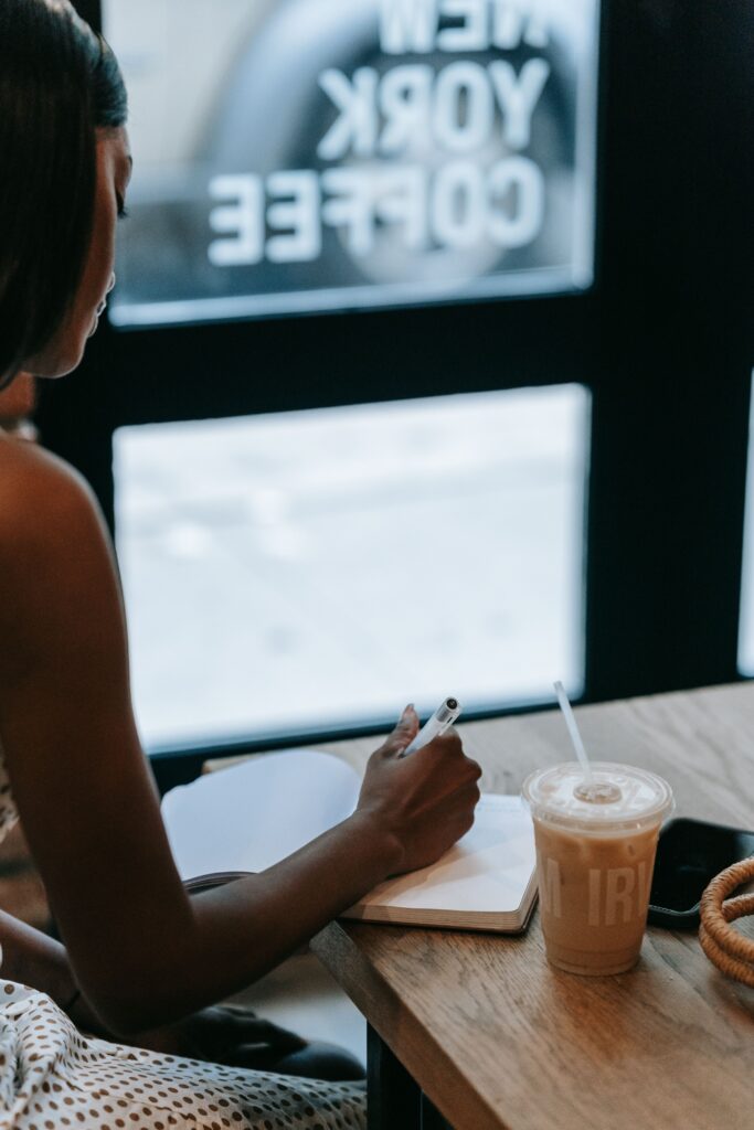 Woman journaling by the window of the coffee shop at New York