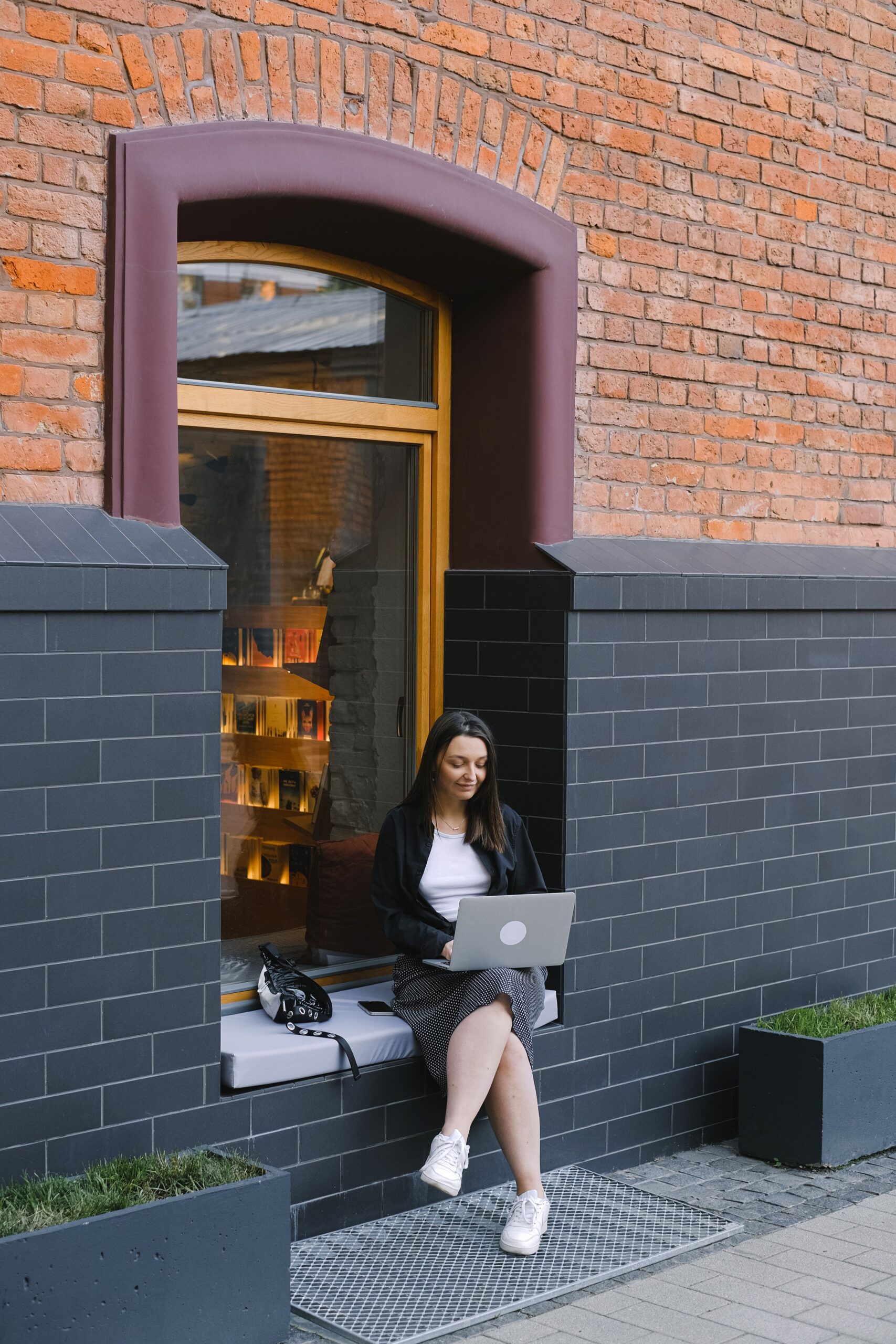 A young professional walking through Manhattan with a laptop bag or coffee, looking thoughtful.