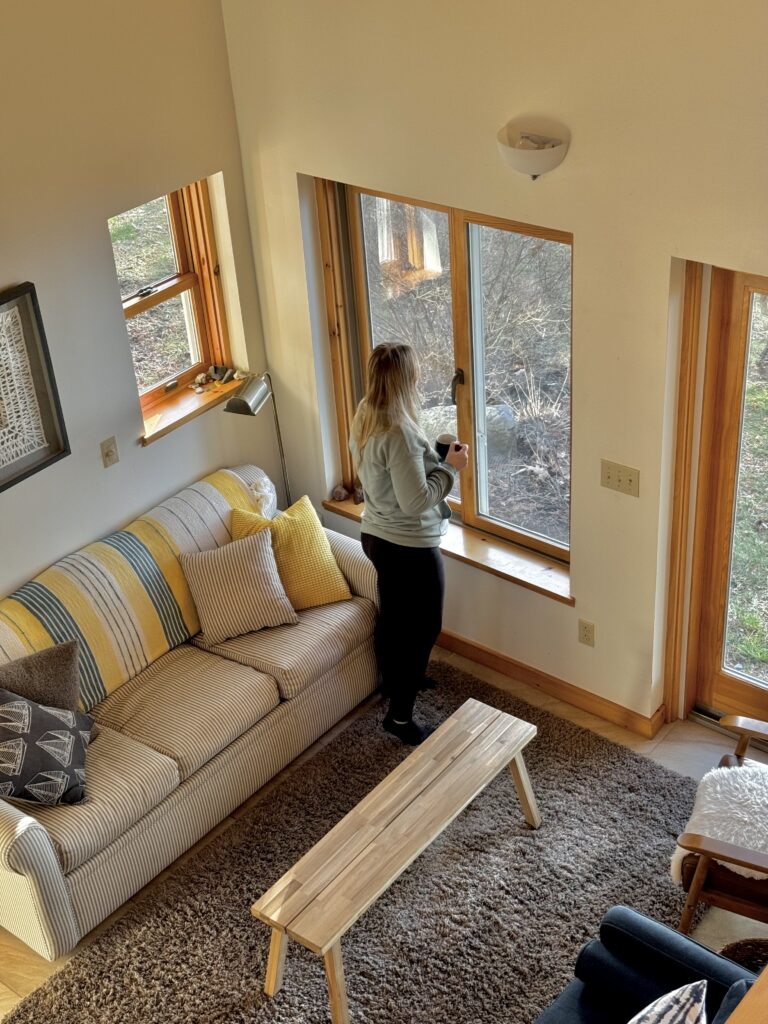 Woman looking out the window at a bright sunny day while comfortably indoors at Manhattan