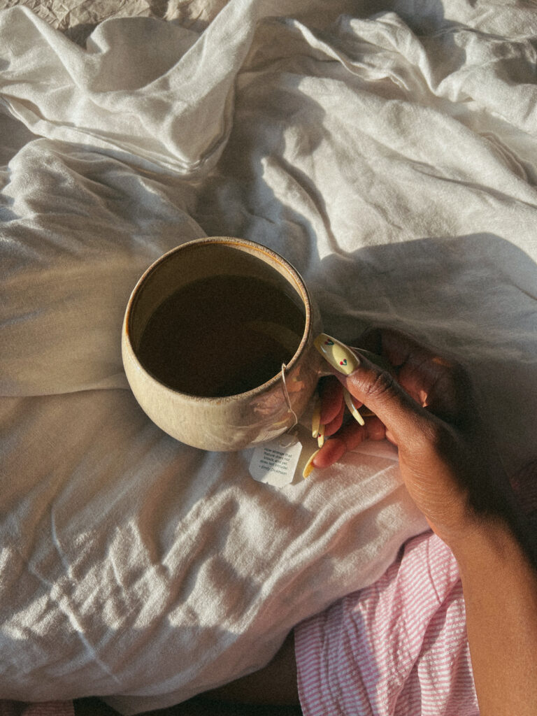 Girl holding a cup of tea overthinking instead of resting properly at New York