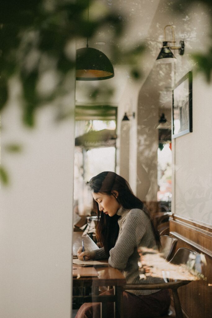 Woman journaling at a cafe and ignoring social media at Brooklyn